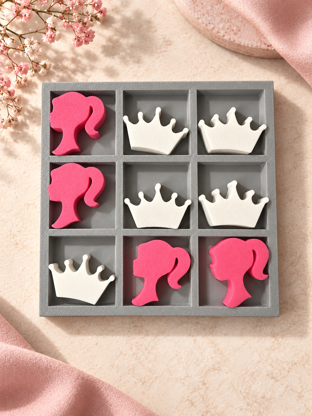 Gray tray tic-tac-toe set with pink girl silhouette pieces and white crown pieces