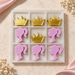 White tray tic-tac-toe set with pink girl silhouette pieces and gold crown pieces, angled view