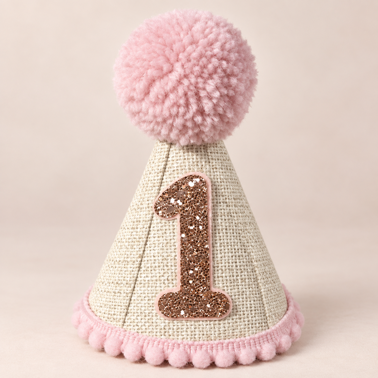 Natural woven first birthday party hat with pink pom pom and rose gold glitter number one